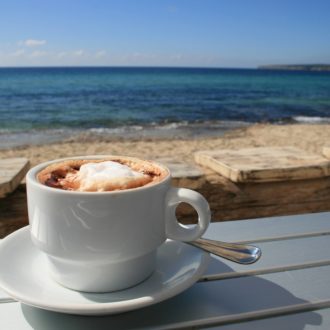 coffee on table looking at beach and water