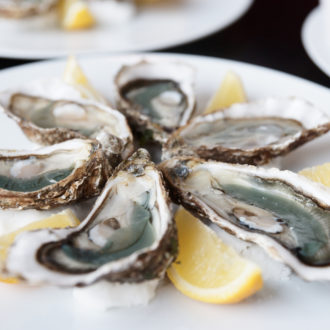 Fresh oysters on plate with lemon