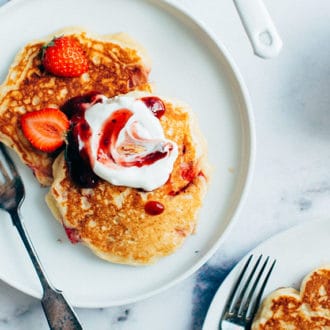 Pancakes with strawberries and cream on plate