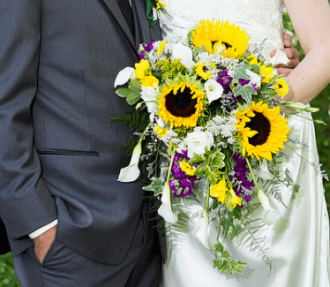 Sunflower wedding bouquet arrangement with bride and groom