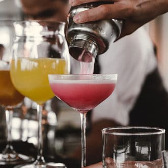 row of cocktails being poured