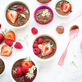table with bowls of chocolate and strawberry desserts
