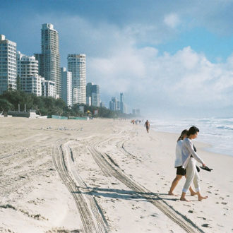 Couple walking on sufer paradise beach, gold coast