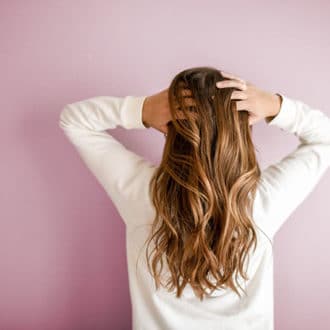 Girl with healthy brown hair and pink background