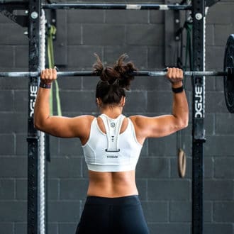 Woman in gym holding weight bar