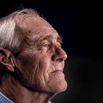 Elderly man with hearing aids