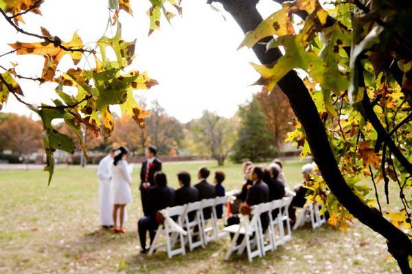 Small intimate wedding ceremony with chair on field