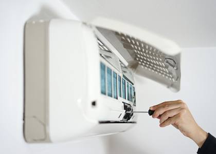 air conditioner being serviced with screwdriver