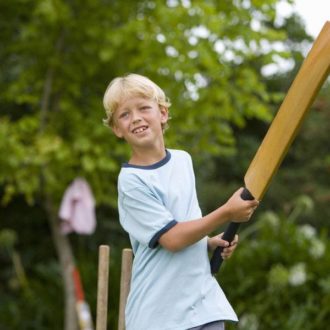 Boy playing backyard cricket