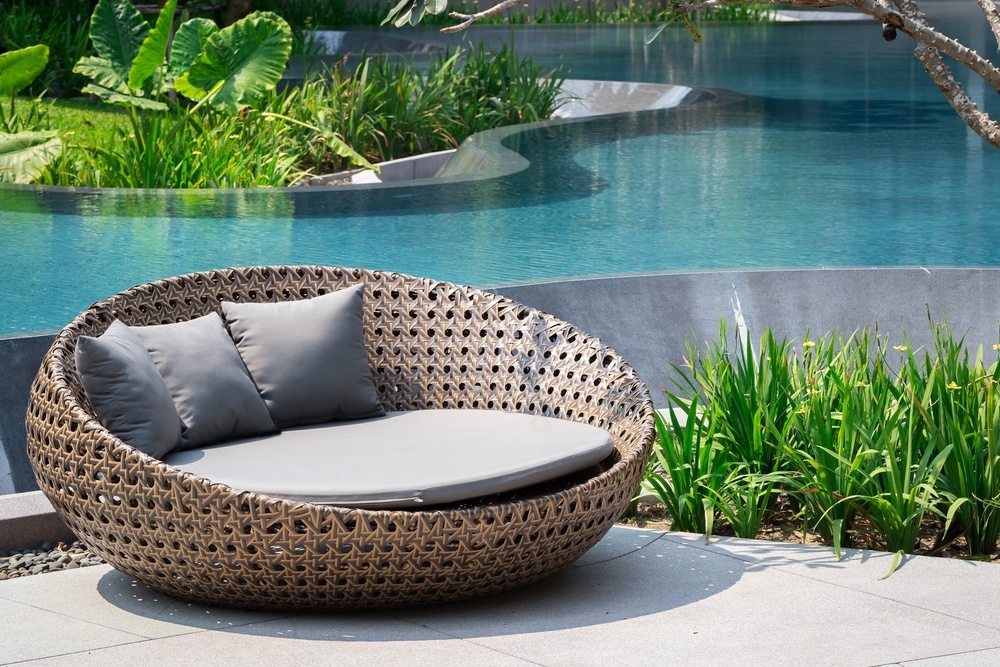A large outdoor seat by a pool