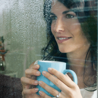Woman drinking coffee looking out of a window