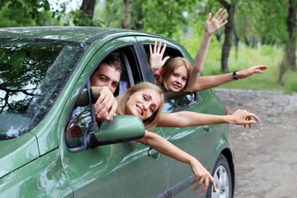 Family in car holding hands out window