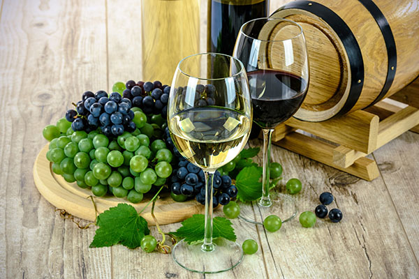 Glasses of red and white wine with grapes