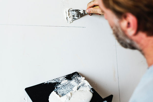 man painting wall white