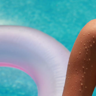 Woman and inflatable pool toy in pool
