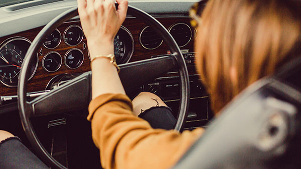 womans hand on car wheel