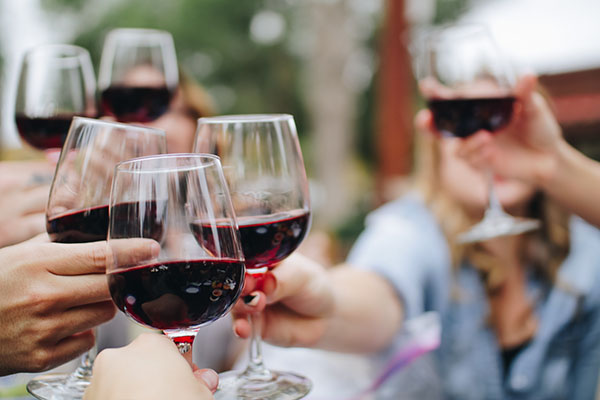 People holding glasses of red wine