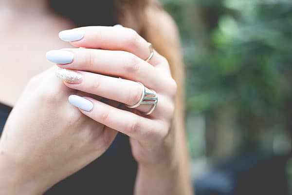 Woman showing pale blue SNS nails