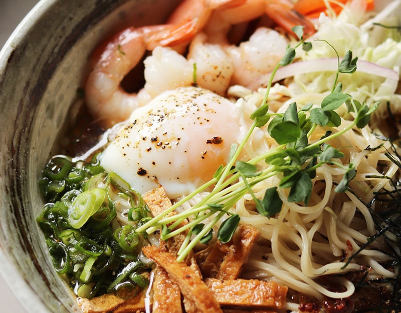 bowl of ramen with egg and prawn and garnish