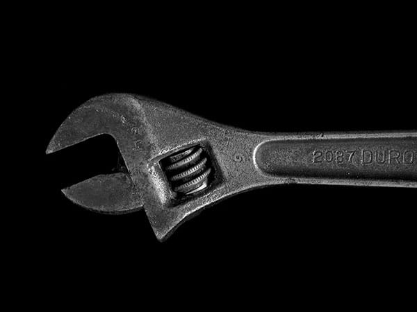 Silver adjustable wrench on black background