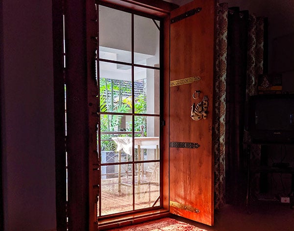 red wood front door with security screen door closed