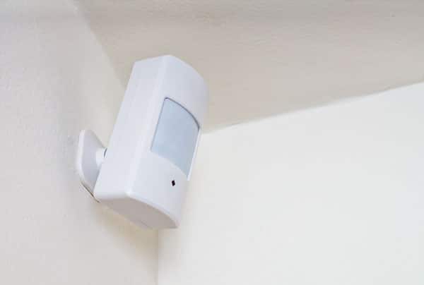 white home security alarm installed on wall