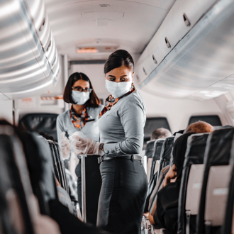 Air hostesses on plane aisle