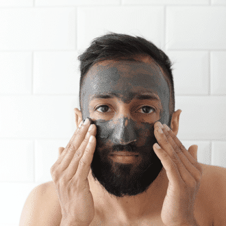 Man using charcoal face mask